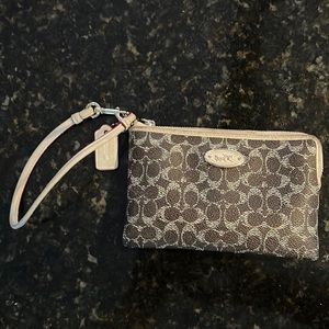 Women’s dark brown/tan classic wristlet in excellent condition. Inside/two slots